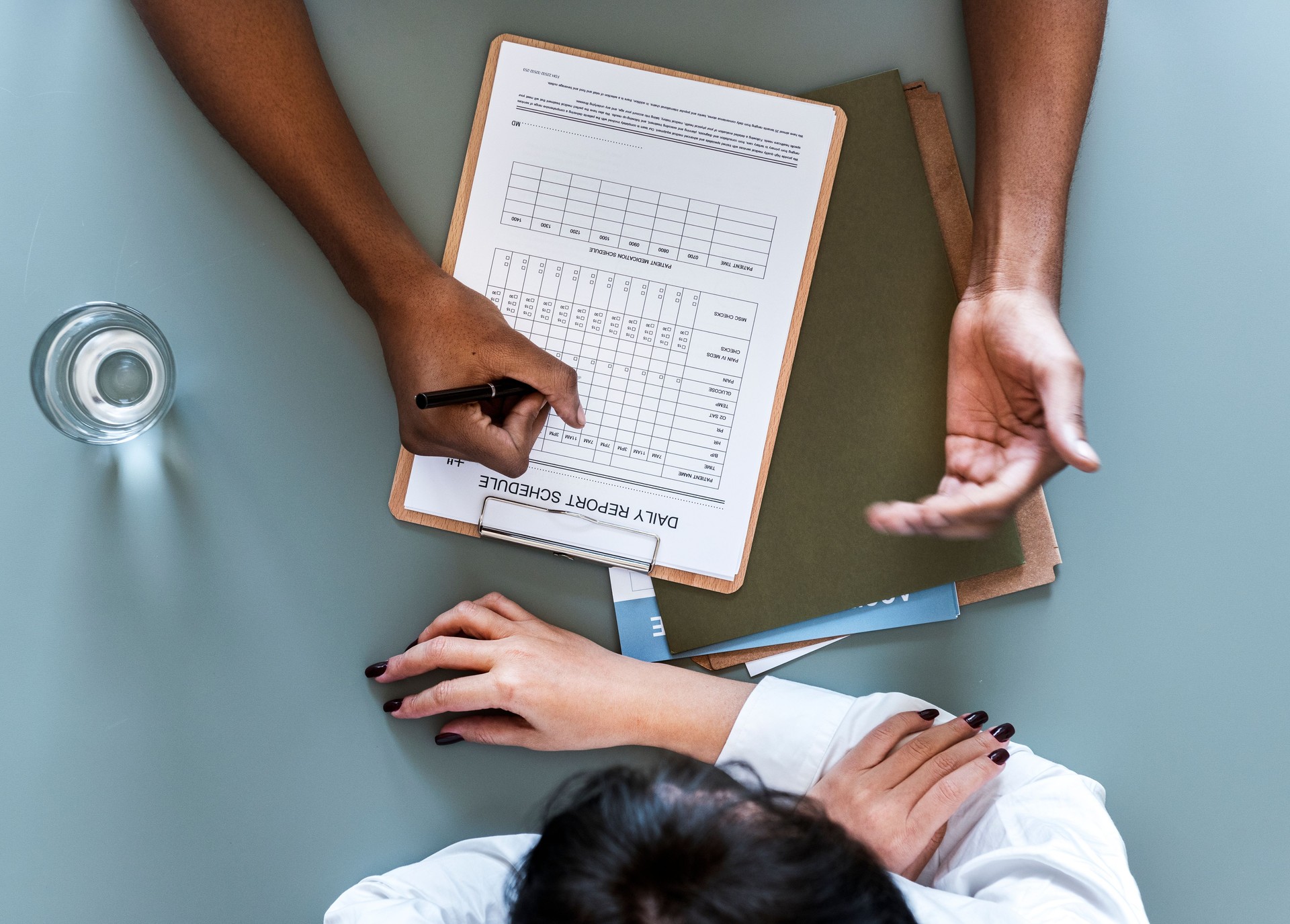 Aerial view of doctor writing patient daily report checklist